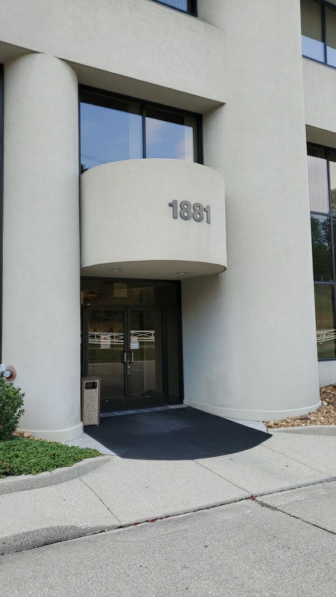 Commercial building entrance, before and after a soft wash after