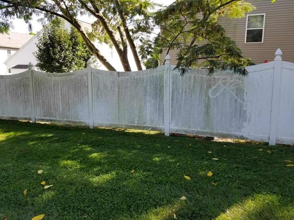 White vinyl privacy fence streaked with green algae and mildew before soft washing by Osborne Pro Wash in Morrow, Ohio